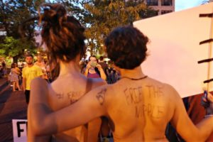In this Aug. 7, 2015, photo, people participate in a topless rally to dispute a city ordinance on exposure that requires women to cover their nipples in Springfield, Mo. Nipples can be exposed in Springfield while the American Civil Liberties Union and city leaders seek to resolve a dispute over an indecent exposure ordinance passed after the topless rally, the ACLU announced Monday, Jan. 25, 2016. (Valerie Mosley/The Springfield News-Leader via AP) NO SALES; MANDATORY CREDIT